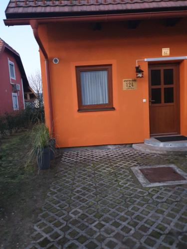 an orange house with a window and a door at Terme Čatež Apartma Nine in Čatež ob Savi