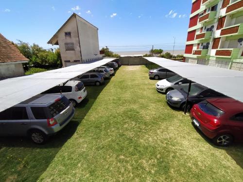 a row of cars parked in a parking lot at MarWal Departamentos in Santa Teresita