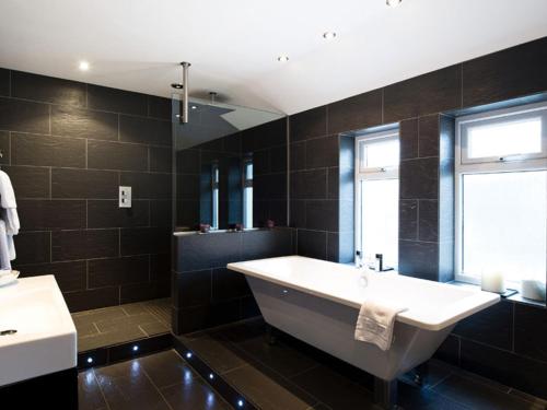 a bathroom with a large tub and a window at Hotel Wrexham in Wrexham