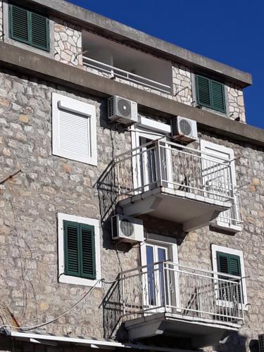 a building with two balconies on the side of it at Apartments Teodora Obala in Petrovac na Moru