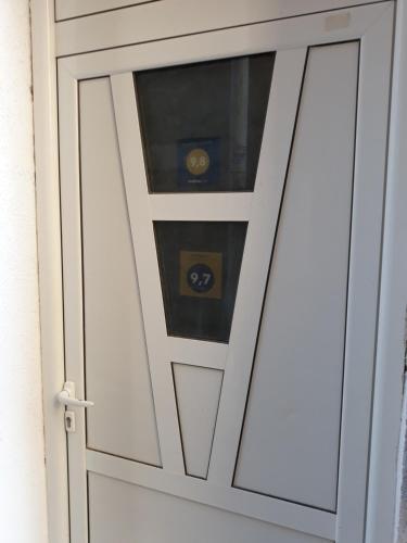 una porta bianca con una finestra dentro di Apartments Teodora Obala a Petrovac na Moru