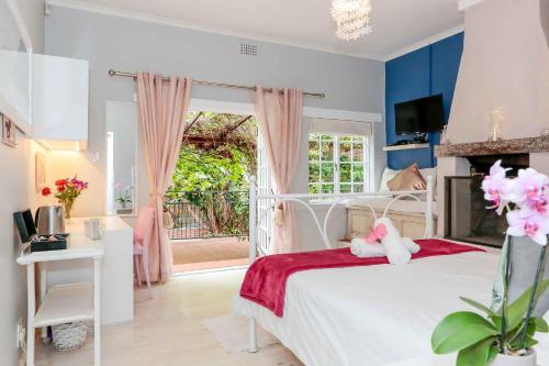 1 dormitorio con cama blanca y ventana en Sacred Mountain Lodge en Noordhoek