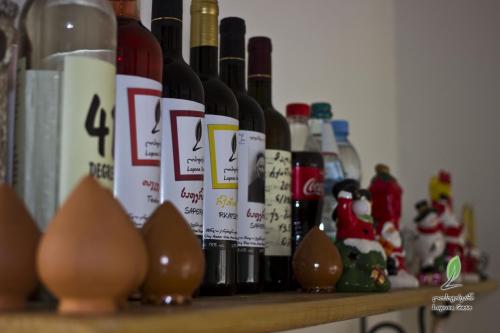 a shelf filled with bottles of wine and christmas ornaments at Hotel Lopota Gate in Napareuli