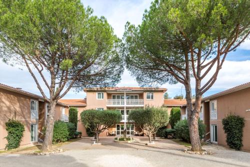 ein Gebäude mit Bäumen davor in der Unterkunft Best Western Plus Hyères Côte D'Azur in Hyères