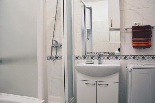 a white bathroom with a sink and a shower at Apartment Center in Split