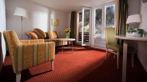 a living room with a couch and chairs and a table at Hotel Silberhorn in Lauterbrunnen