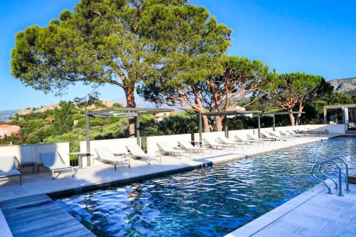 a swimming pool with lounge chairs next to a swimming pool at La Villa Calvi in Calvi