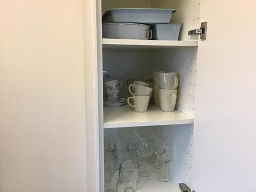a cupboard filled with cups and vases at Nordanå Gård in Strö