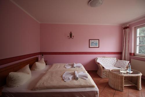 a bedroom with two beds and a table and a window at Landhaus Alt Reddevitz in Middelhagen
