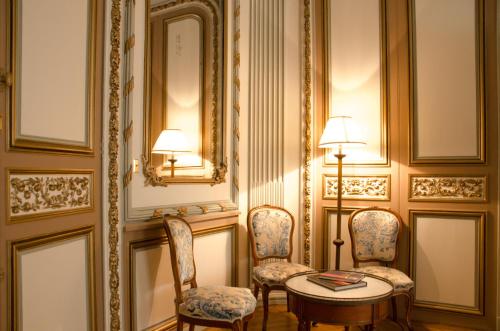 une pièce avec des chaises, une table et un miroir dans l'établissement Villa Victor Louis - Bordeaux Centre, à Bordeaux