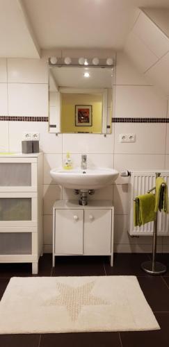 ein Bad mit einem Waschbecken und einem Spiegel in der Unterkunft Ferienwohnungen Faber in Kreuzwertheim