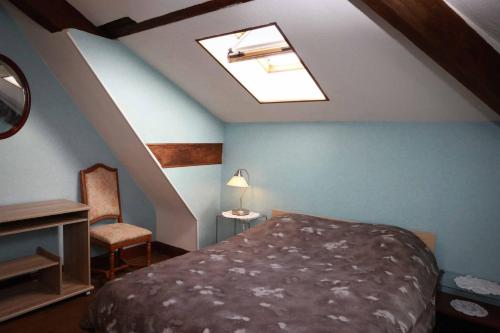 a attic bedroom with a bed and a skylight at La Dragée Hôte, Chambres chez l'habitant in Verdun