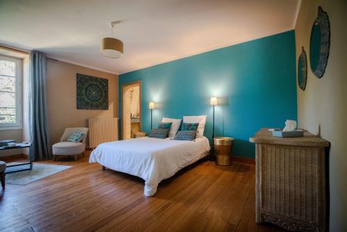 - une chambre avec un lit et un mur bleu dans l'établissement Gîte entre Bordeaux et Saint-Emilion, à Génissac