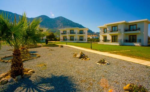 a house with a palm tree in front of it at Hotel Sempati in Kérynia