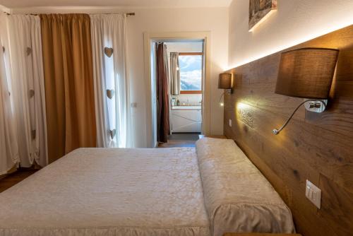 a bedroom with a bed and a lamp and a window at Locanda Zita in Sestola