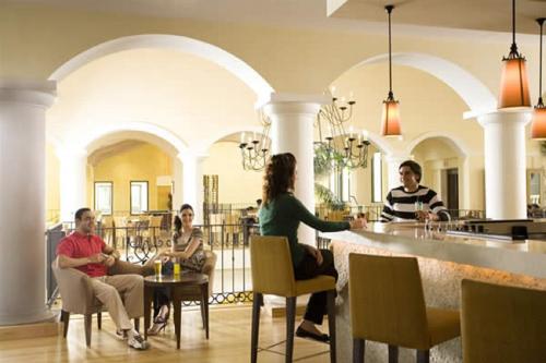 un grupo de personas sentadas en un bar en un restaurante en Casa Emperador Penthouse, en Roldán
