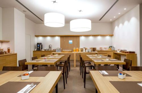 a dining room with wooden tables and chairs at HSM Hotel San Martino in Garbagnate Monastero 