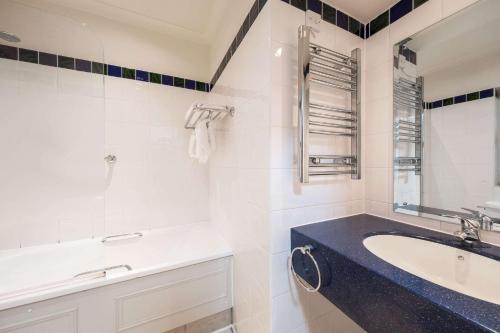 a white bathroom with a sink and a mirror at Makeney Hall Hotel in Derby