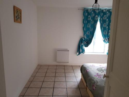 1 dormitorio con ventana y suelo de baldosa en Jolie appartement moderne à Roanne, en Roanne