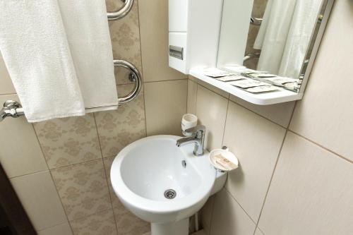 a bathroom with a toilet and a sink and a mirror at Petrovsky Hotel in Kamensk-Shakhtinskiy