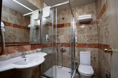 een badkamer met een douche, een toilet en een wastafel bij Cactus Fleur Beach in Yalıkavak