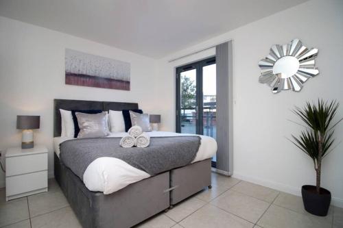 um quarto com uma cama grande e um espelho em No1 Beach Walk by Stay South Wales - FREE Parking em Swansea