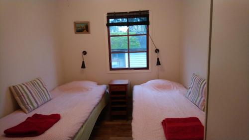 two twin beds in a room with a window at Björboholm in Gråbo