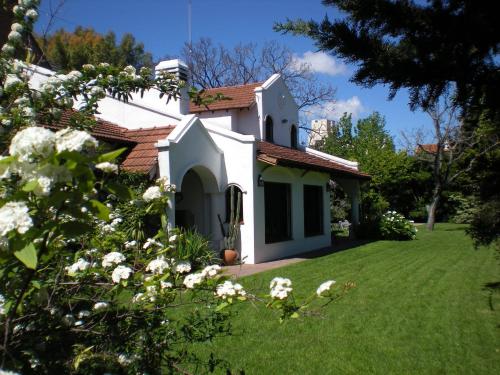 a small white house with a green yard at Susana Just Boutique Hotel in Vicente López