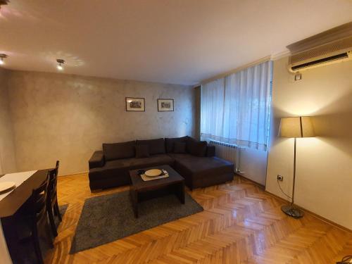 a living room with a black couch and a table at Central Park Apartments in Belgrade