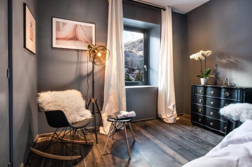 1 dormitorio con silla, vestidor y ventana en Le Clos Caroline en Brides-les-Bains