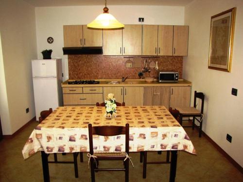 eine Küche mit einem Tisch und eine Küche mit einem Kühlschrank in der Unterkunft Appartamento Serena in Ponti Sul Mincio
