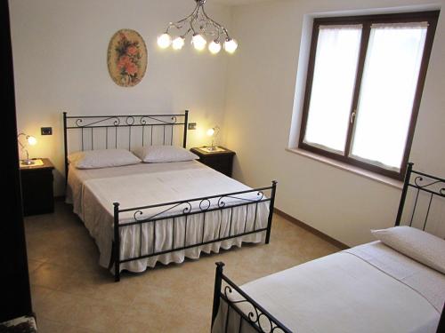 1 Schlafzimmer mit 2 Betten und 2 Fenstern in der Unterkunft Appartamento Serena in Ponti Sul Mincio