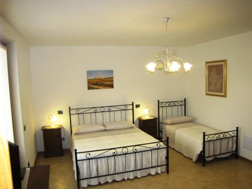 1 Schlafzimmer mit 2 Betten und einem Kronleuchter in der Unterkunft Appartamento Serena in Ponti Sul Mincio