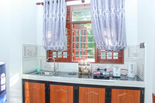 een keuken met een wastafel en een raam bij Temple Tree Mirissa in Mirissa