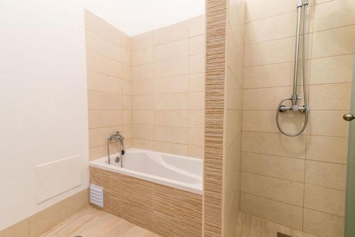 a bathroom with a bath tub and a shower at Cozy Fuseta Townhouse with Terrace Roof Solarium, 5min to Beach in Fuzeta