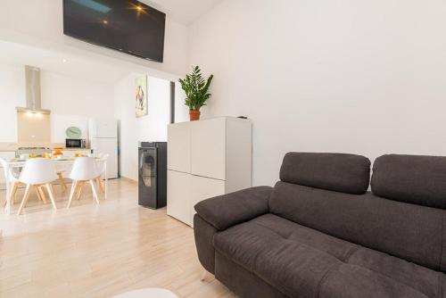 a living room with a couch and a kitchen at Cozy Fuseta Townhouse with Terrace Roof Solarium, 5min to Beach in Fuzeta