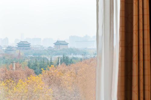 a window with a view of trees and buildings at Holiday Inn Express Xi'an Ancient Town West by IHG in Xi'an