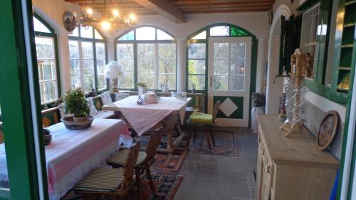 Zimmer mit einem Tisch, Stühlen und Fenstern in der Unterkunft Hirschenhof in Graz