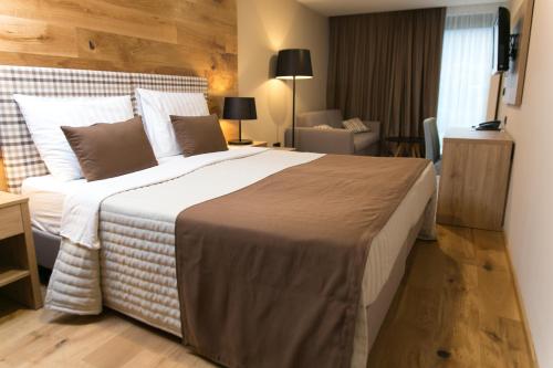 - une chambre avec un grand lit dans une chambre d'hôtel dans l'établissement Korona, Resort & Entertainment, à Kranjska Gora