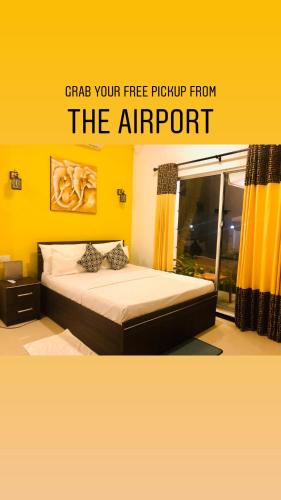 a bed in a room with a yellow wall at White Villa Airport Transit Hotel in Katunayake