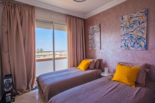 a bedroom with two beds and a window with a view at Mosquee & Sea View Casablanca in Casablanca