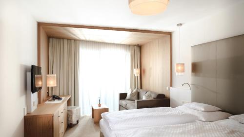 イシュグルにあるHotel Trofana Alpinのベッド2台と窓が備わるホテルルームです。