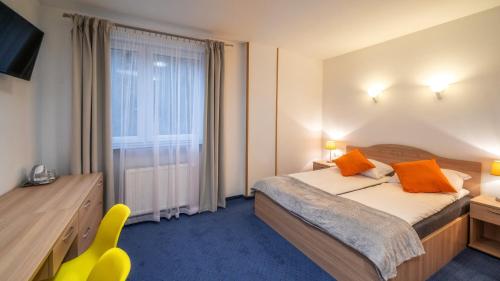 a hotel room with a bed and a window at Gronie Ski & Bike in Szczyrk