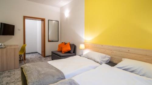 a hotel room with two beds and a chair at Gronie Ski & Bike in Szczyrk