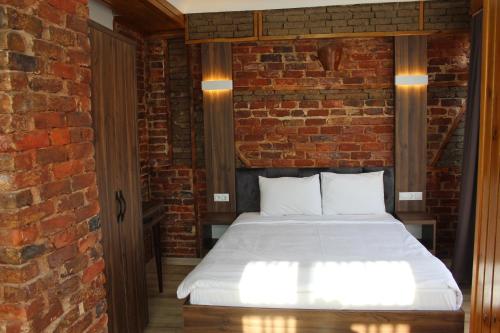 a bed in a room with a brick wall at Han Suite Hotel in Istanbul