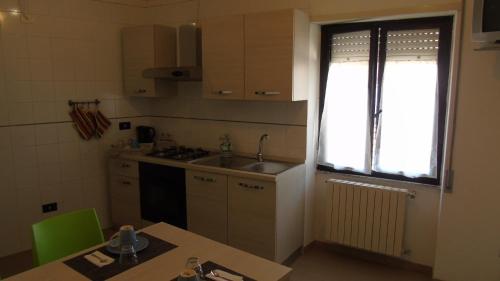 mała kuchnia ze zlewem i oknem w obiekcie B & B MARIMA ORGOSOLO w mieście Orgosolo