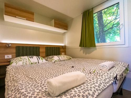 a bedroom with a bed and a window at Holiday resort & camping Bela krajina - river Kolpa in Metlika