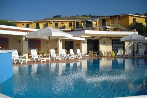 Marasusa Tropea في بارغيليا: حمام سباحة كبير مع كراسي ومظلات