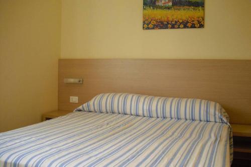 Marasusa Tropea في بارغيليا: غرفة نوم بسرير مع لحاف مخطط