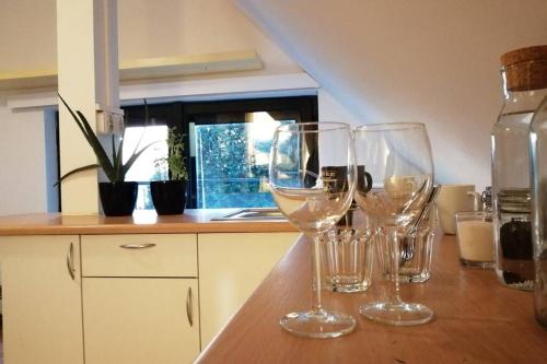Koci Dom في فياليتشكا: ثلاثة أكواب من النبيذ تجلس على منضدة في المطبخ